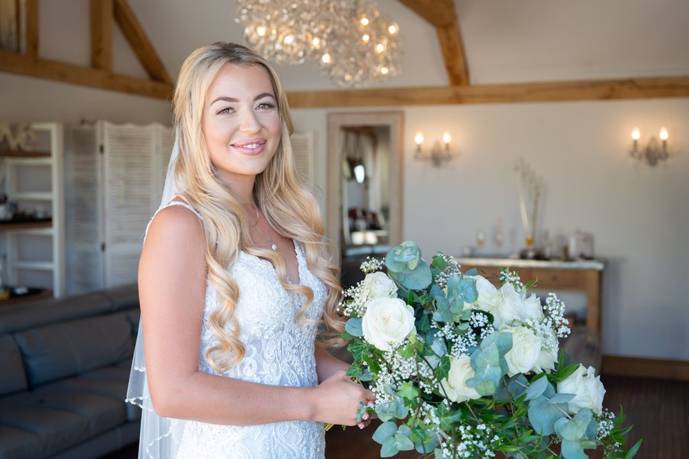 Elegant Bride poses in the bridal dressing room with exposed wooden beams and crystal chandeliers, just ahead of her cooling castle wedding.