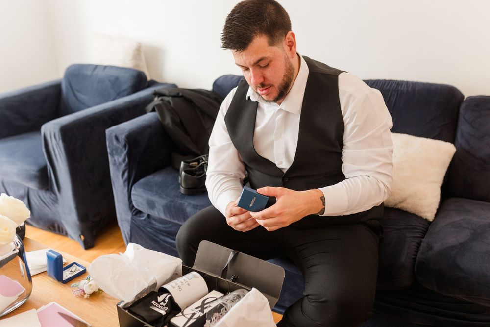 Professional in business attire working at desk with laptop and smartphone in modern office setting.