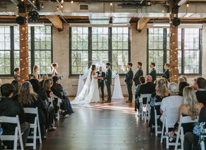 Panoramic view of modern industrial wedding venue with exposed brick walls and large windows.