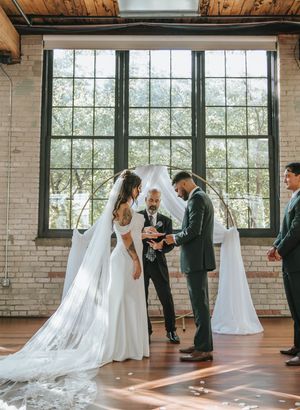 A wedding ceremony sequence in a rustic industrial venue with exposed brick walls and large windows letting in natural light.