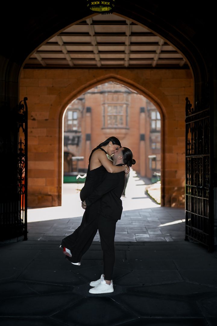 Silhouetted figures in an arched passageway create dramatic shadows and lighting effects.