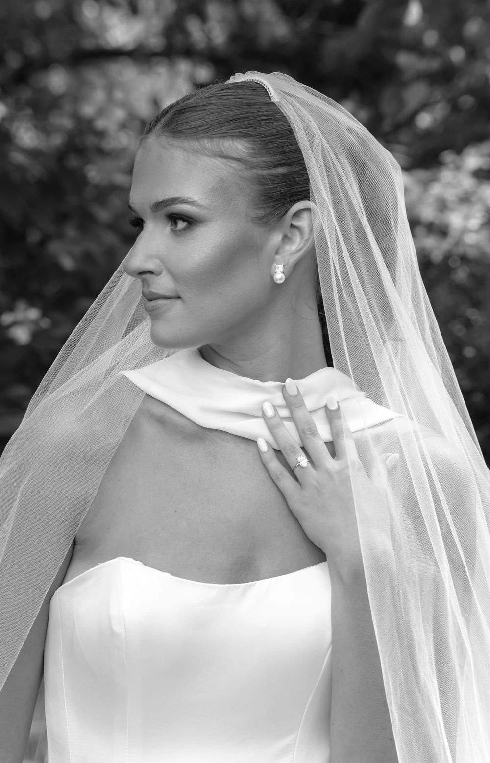 Elegant bridal portrait in black and white showing a classic wedding veil and gown.