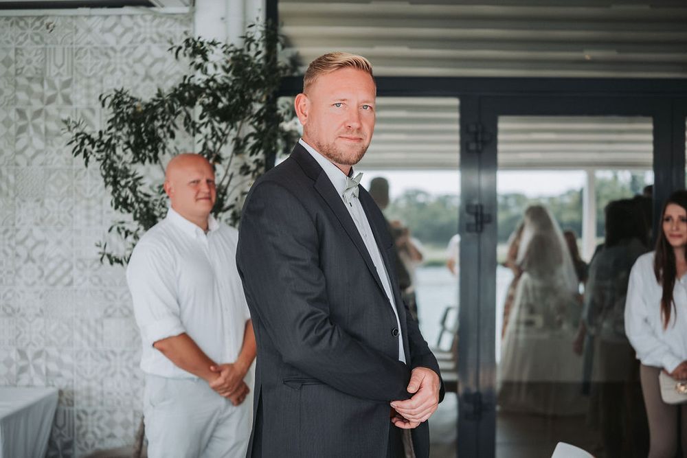 A couple shares an intimate moment during a wedding ceremony in an elegant indoor venue.