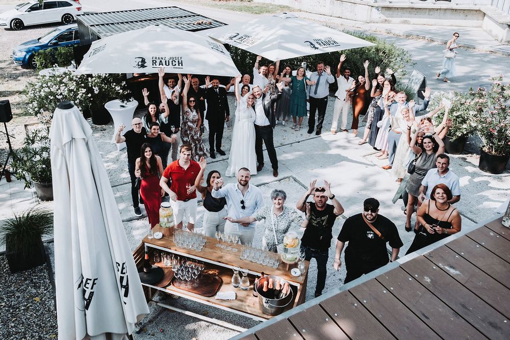 Outdoor wedding ceremony setup with white chairs and floral arrangements under a white tent canopy.