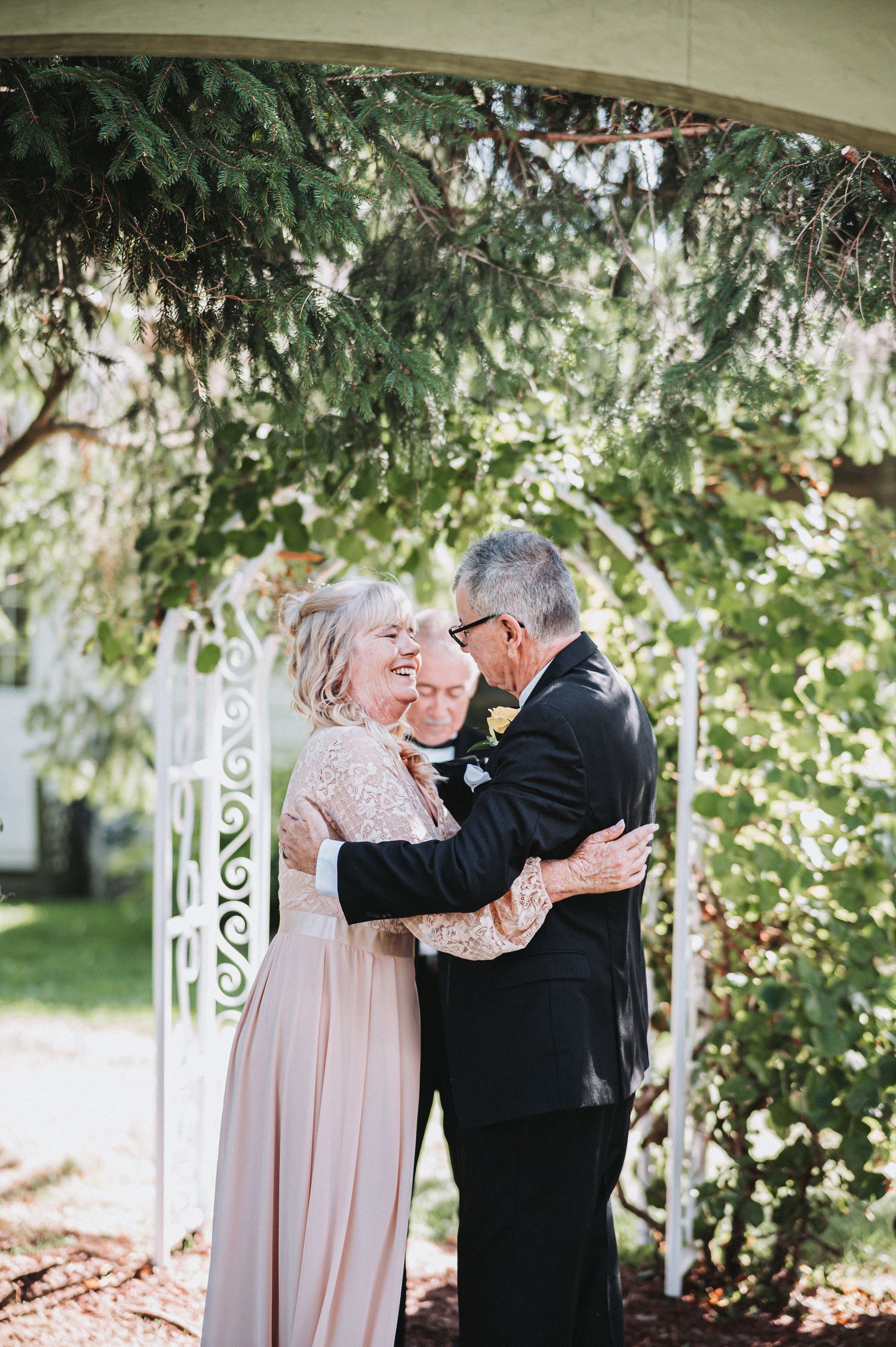 An elegant outdoor wedding ceremony setup with flowing willow trees in the background.