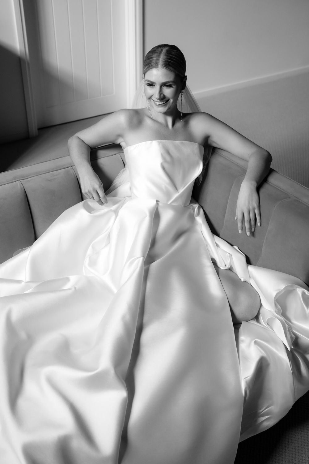 A sequence of black and white photos showing someone reclining in flowing white fabric on a couch.