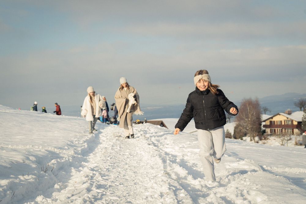 People enjoying a winter walk on a snow-covered mountain trail.