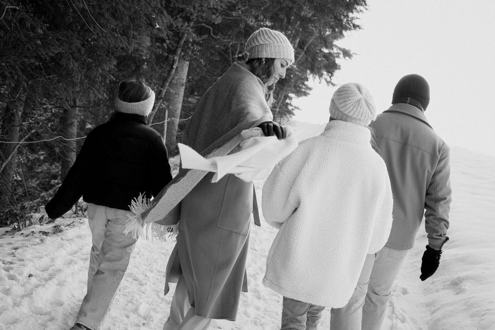A group walks together through a snowy winter landscape.