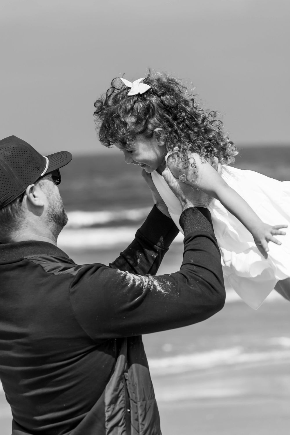 A series of black and white photos showing someone drinking from a glass against an ocean backdrop.