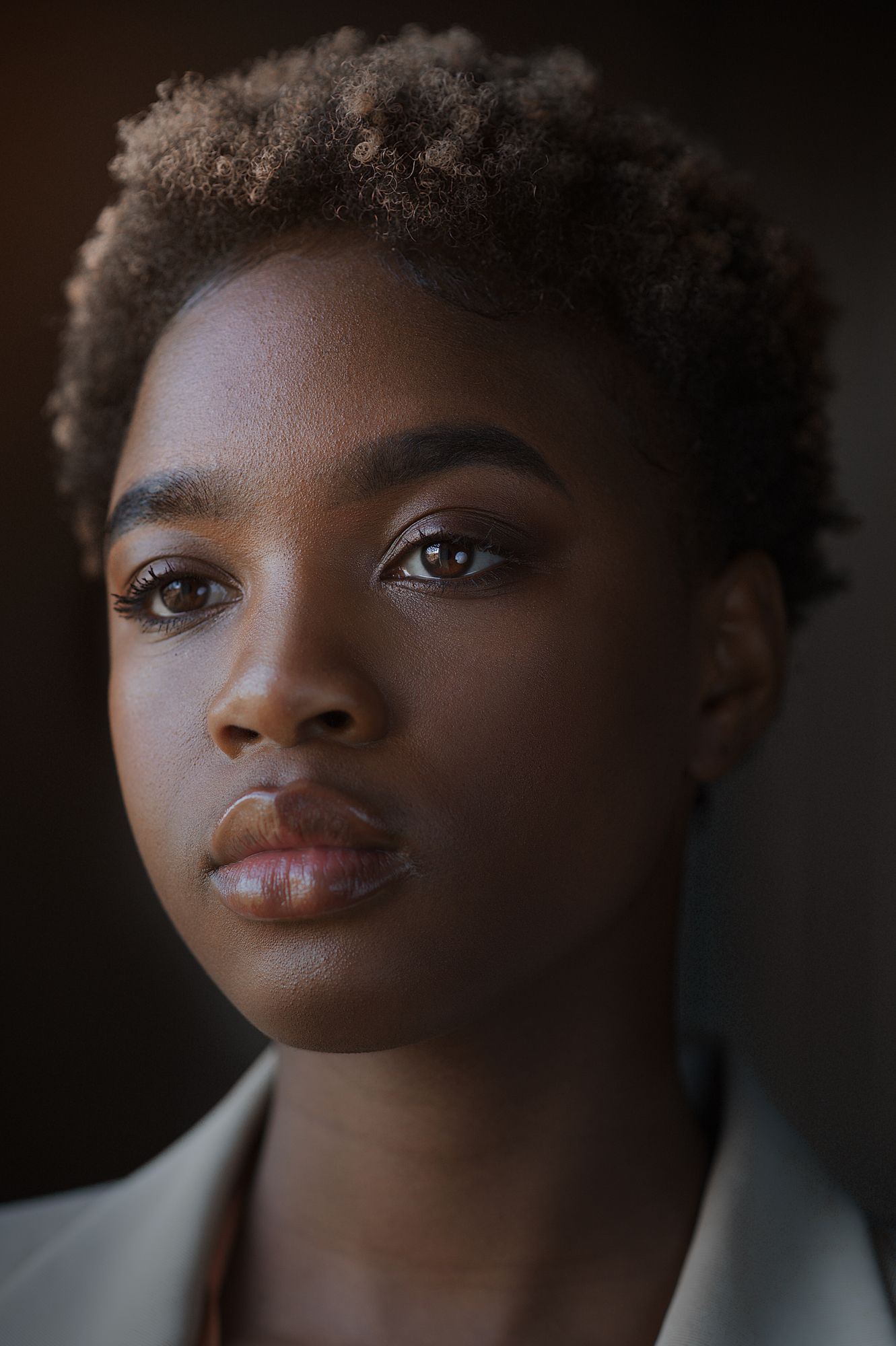 Close up artistic portrait series showing different angles in dramatic lighting against dark background.