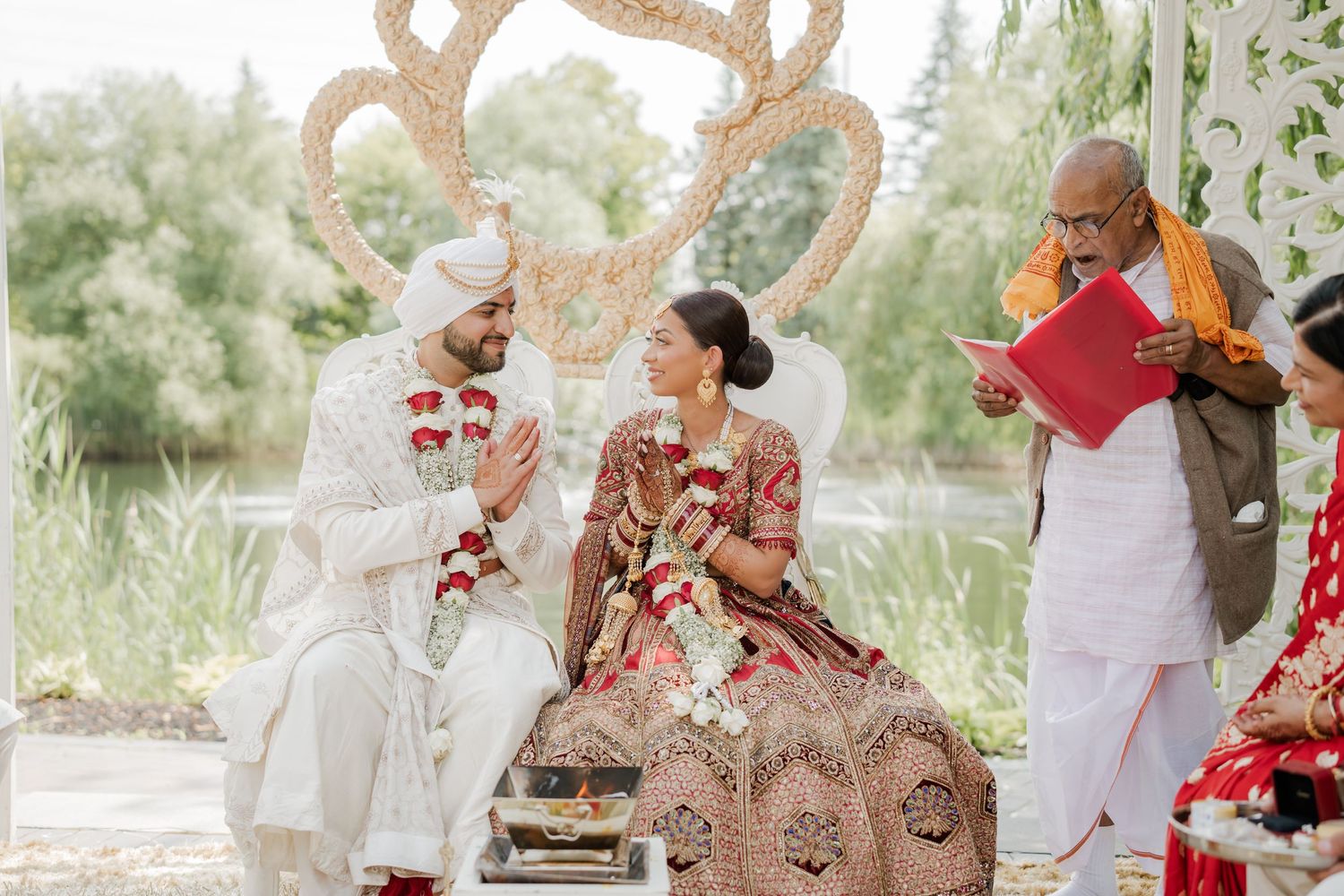 A traditional Indian wedding ceremony with the couple performing rituals under a decorated outdoor mandap.