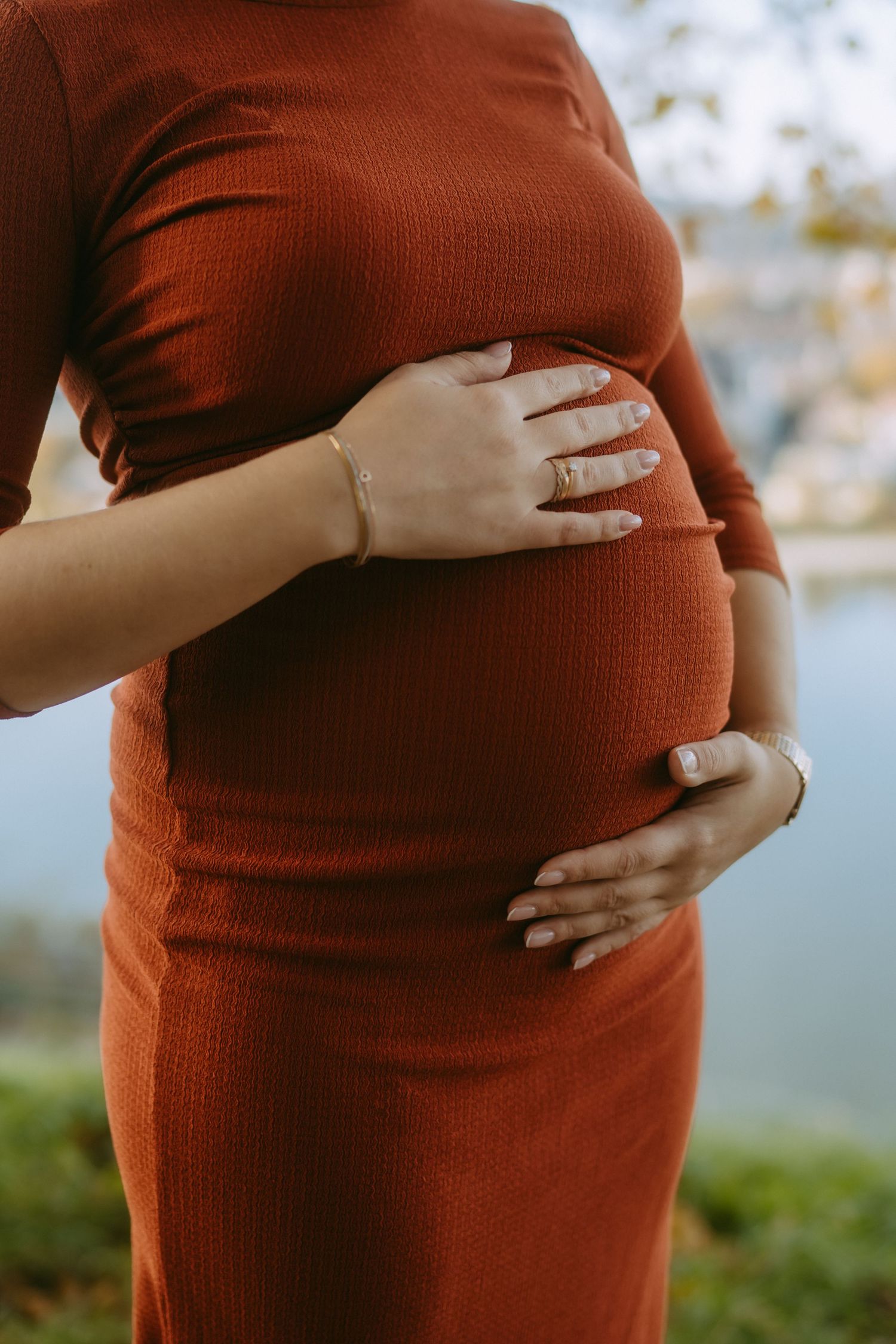 Frau berührt ihren schwangeren Bauch, Detailfoto der Hände