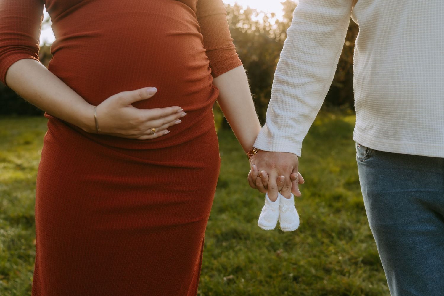 Frau und Mann halten Babyschuhe in den Händen
