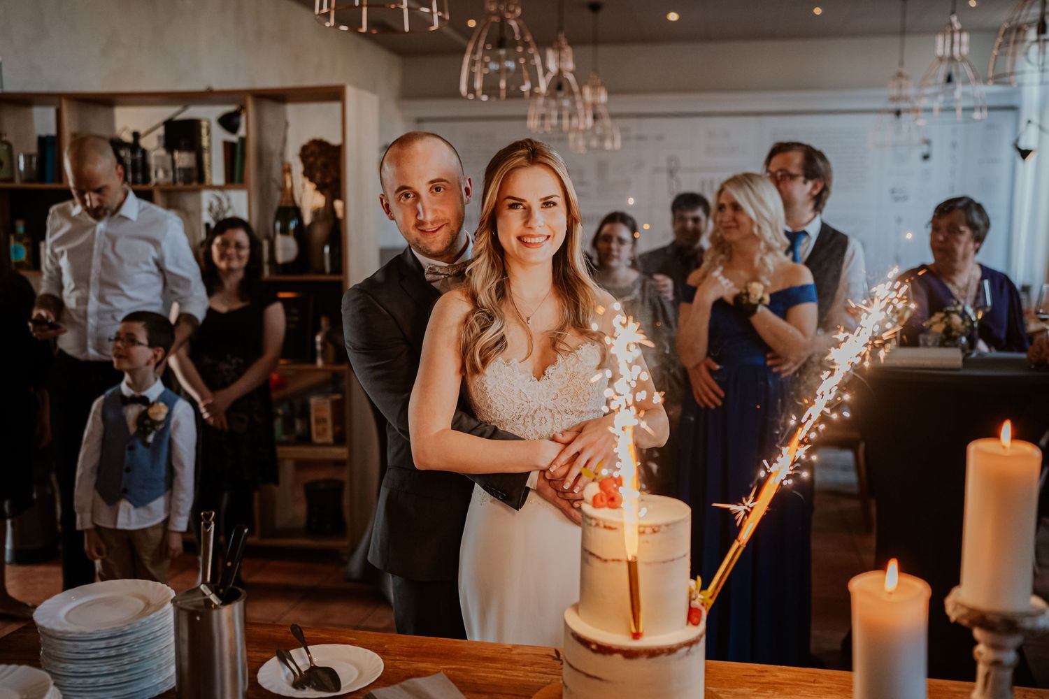 Intimate romantic couple sharing tender kisses in moody lighting with warm orange glow.