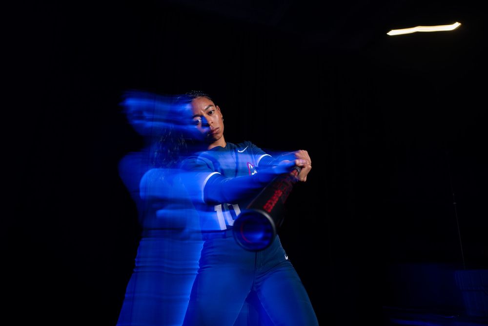 Performer in blue outfit creates motion blur effect during dark stage show.