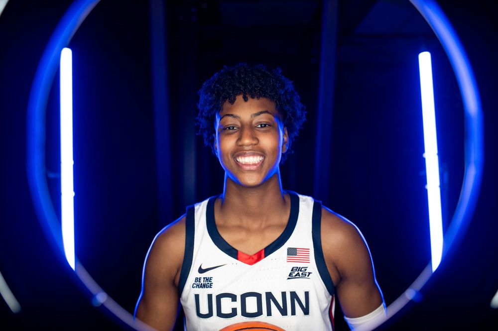 UConn basketball player Ayanna Patterson, poses against illuminated circular backdrop.