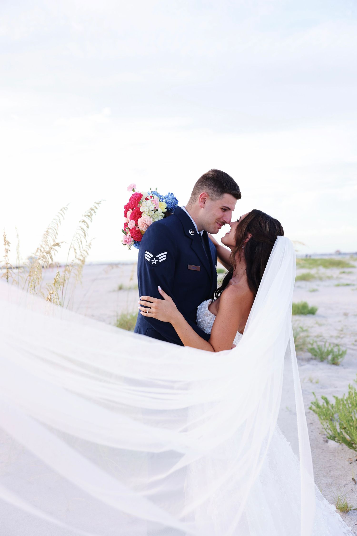 Wedding couple sharing intimate moment with bride holding white floral bouquet.