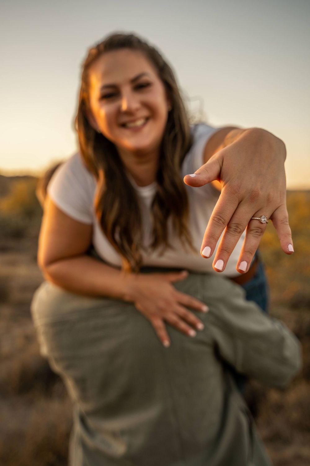 A series of photos showing hands displaying an engagement ring at sunset in a golden-lit outdoor setting.