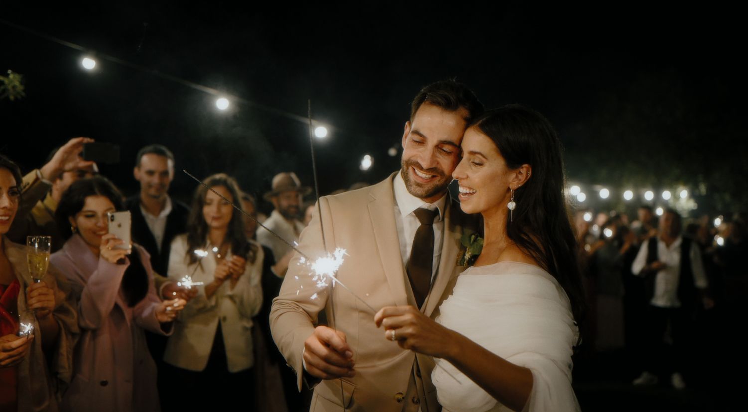 Couple sharing an intimate moment under string lights at nighttime wedding reception.