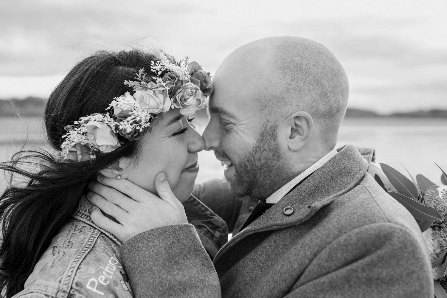 Intimate black and white portrait of couple sharing tender moment outdoors.