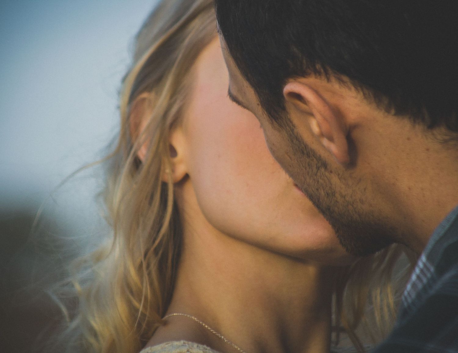 Intimate close-up of a romantic kiss with soft natural lighting.