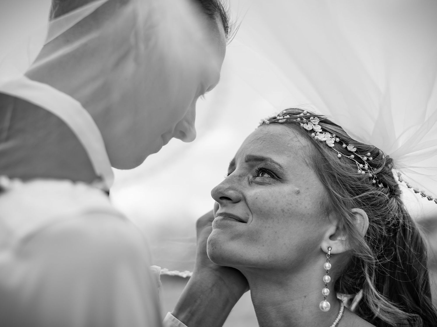 Black and white intimate wedding portrait showing tender moment between couple.