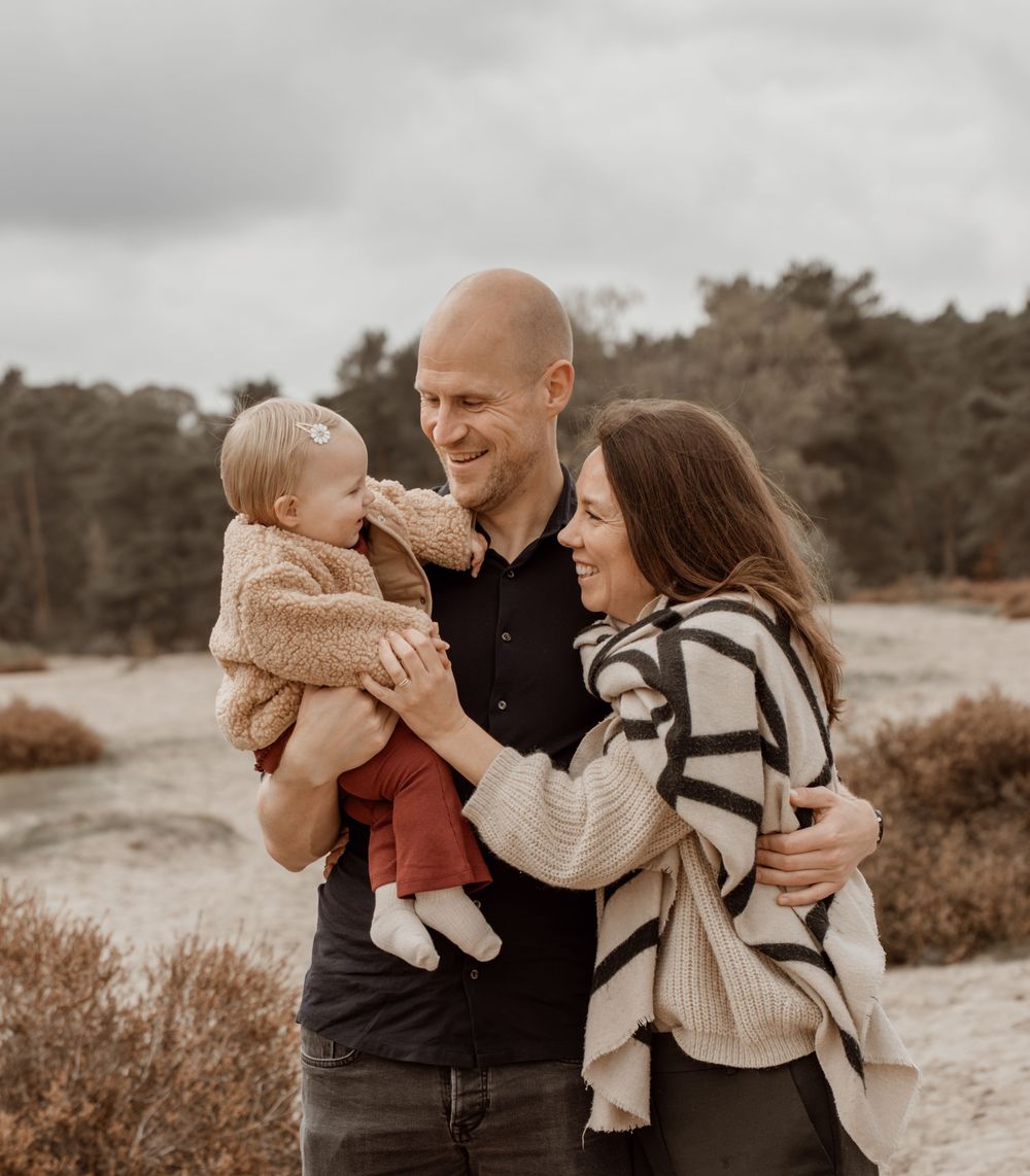 A family shares tender moments together outdoors in warm autumn light during a lifestyle photoshoot.