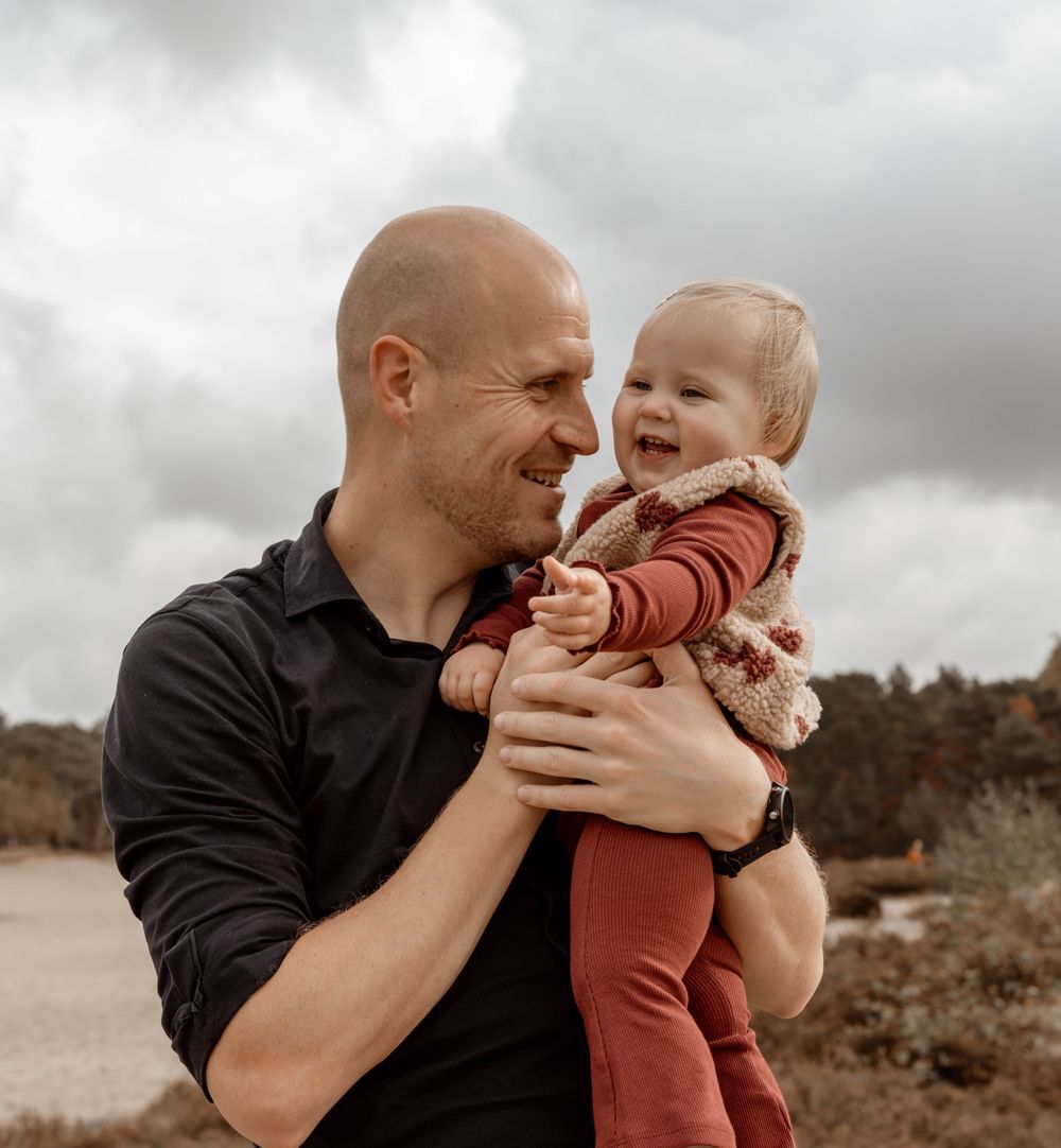 A loving family embraces and plays together during an outdoor autumn photography session.