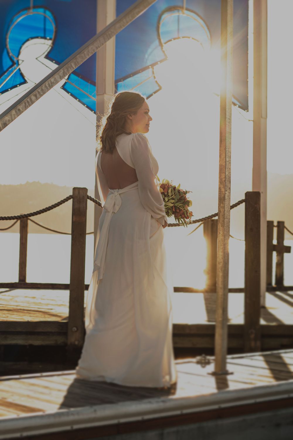 A bride on a board walk in a portrait in CDA Idaho. Taken by Jessica Rae Photography.