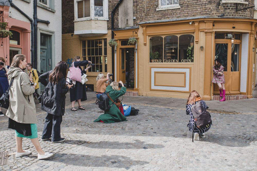 Group of photographers taking pictures in a quaint European town square.