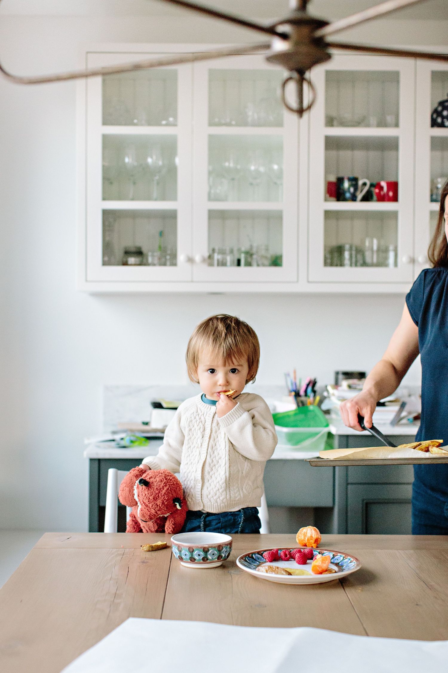 toddler enjoying snack time on kitchen table