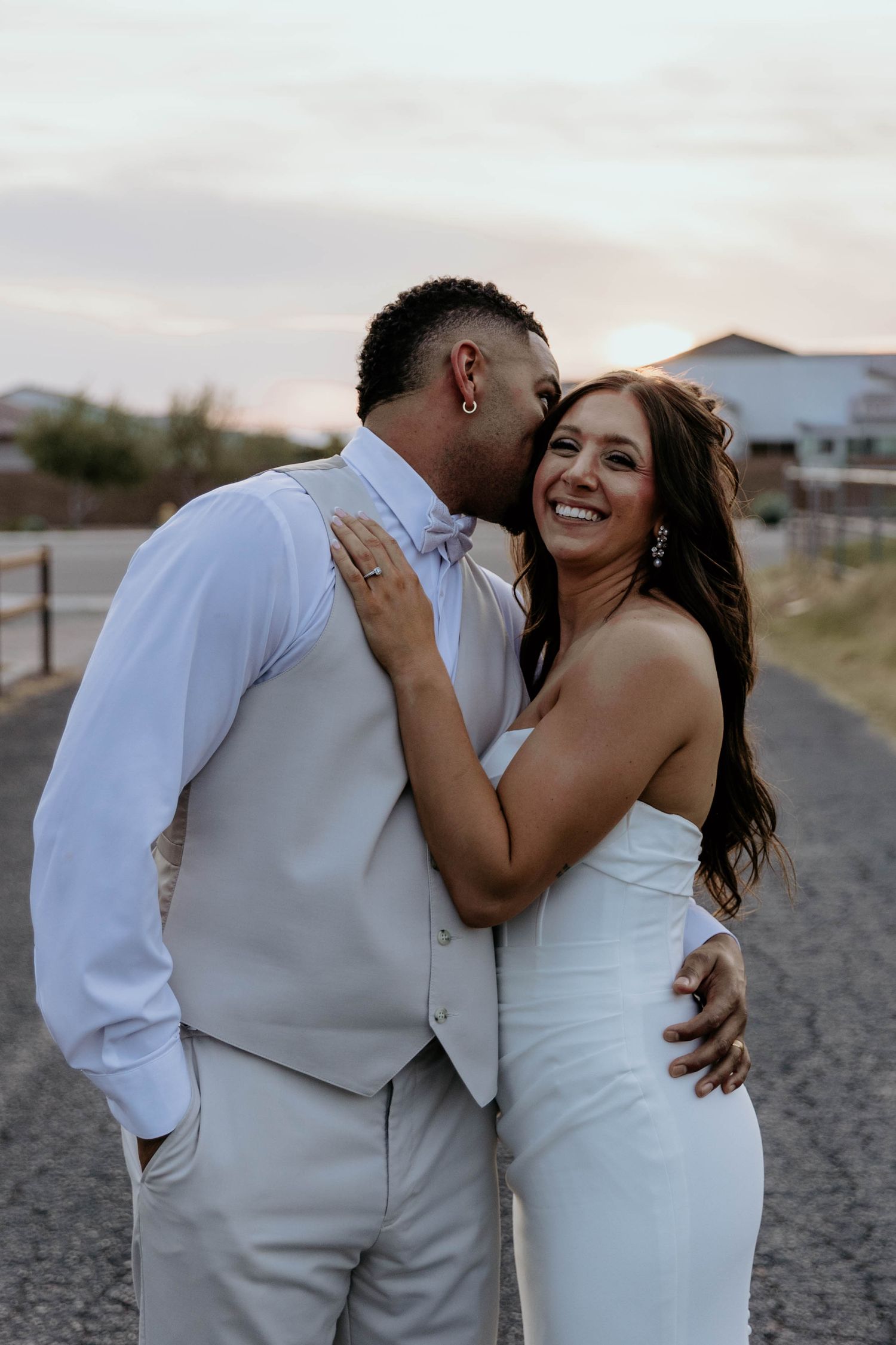 Two people walking up a bright white staircase, with one wearing a white wedding dress and another in a black suit.