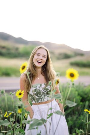Joyful outdoor photography session amongst blooming sunflowers and greenery in a natural landscape setting.
