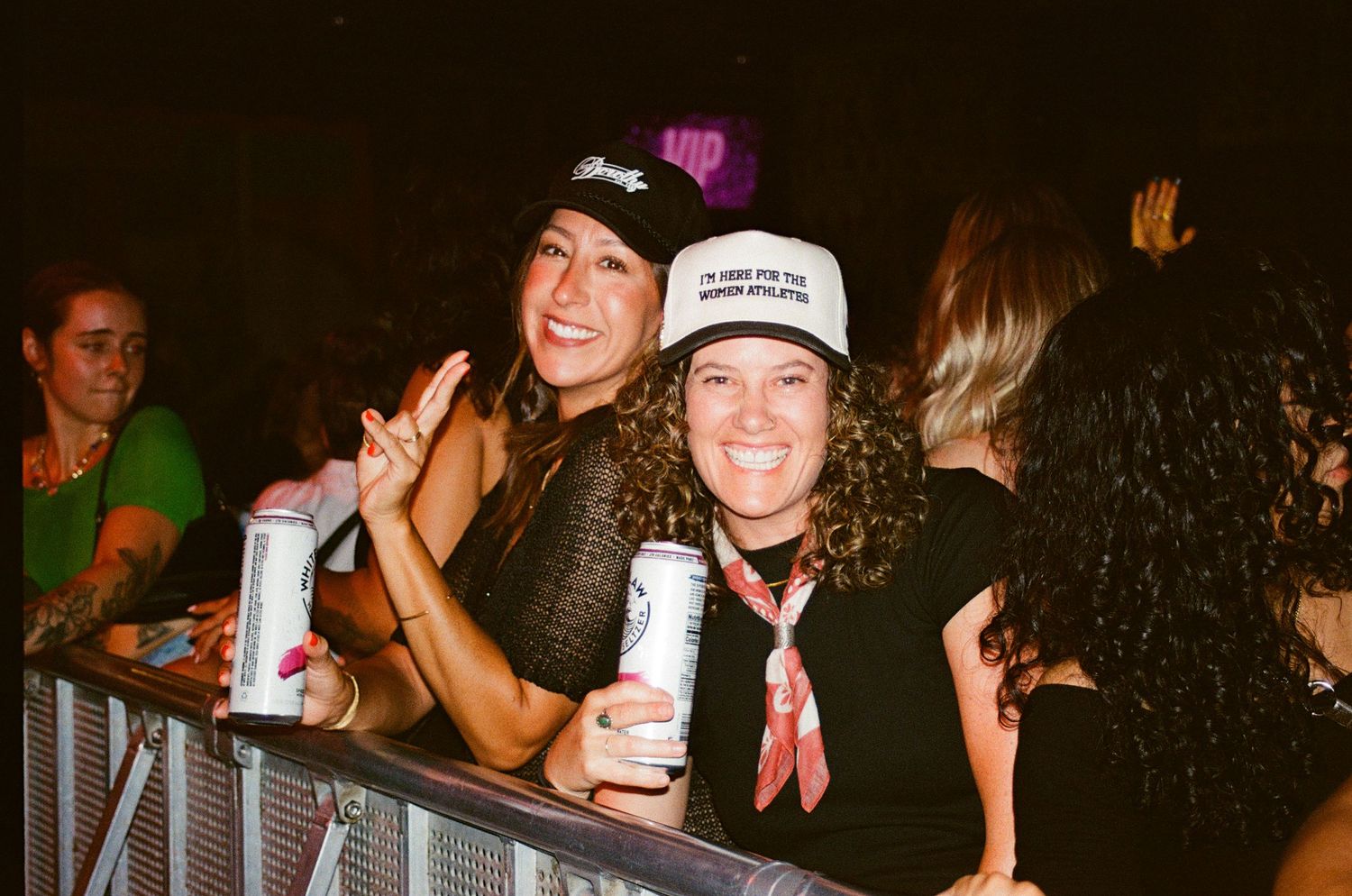 Two women smile at the camera in a dark nightclub, taken at House of Blues for Out and Abtt
