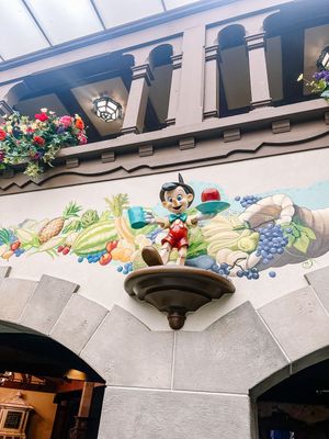 Decorative ceiling archways with murals and paintings adorned with colorful flowers and cartoon characters in a Disney theme.