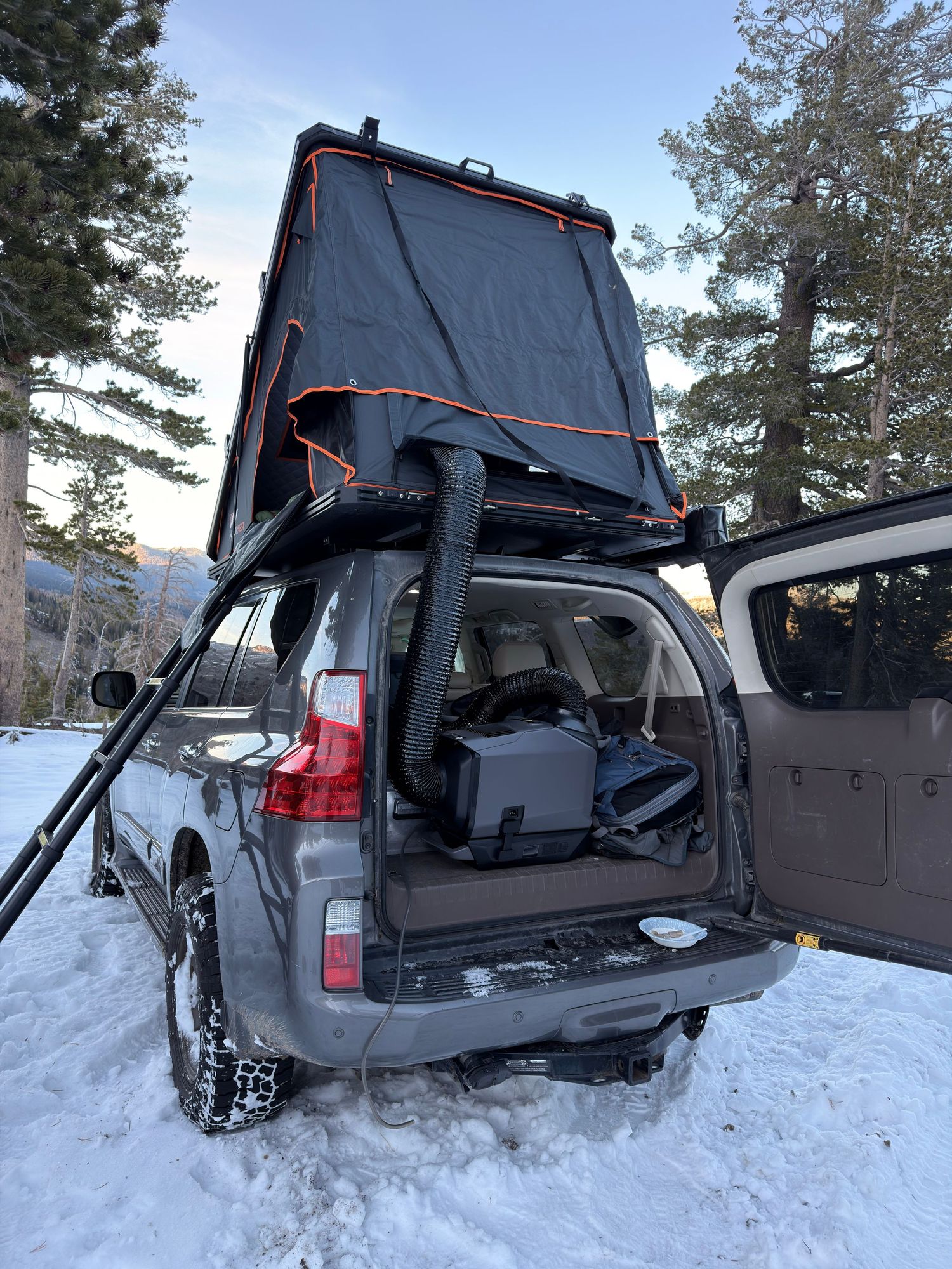 A black truck's tailgate is shown in multiple positions demonstrating its multi-function opening capabilities in snowy conditions.