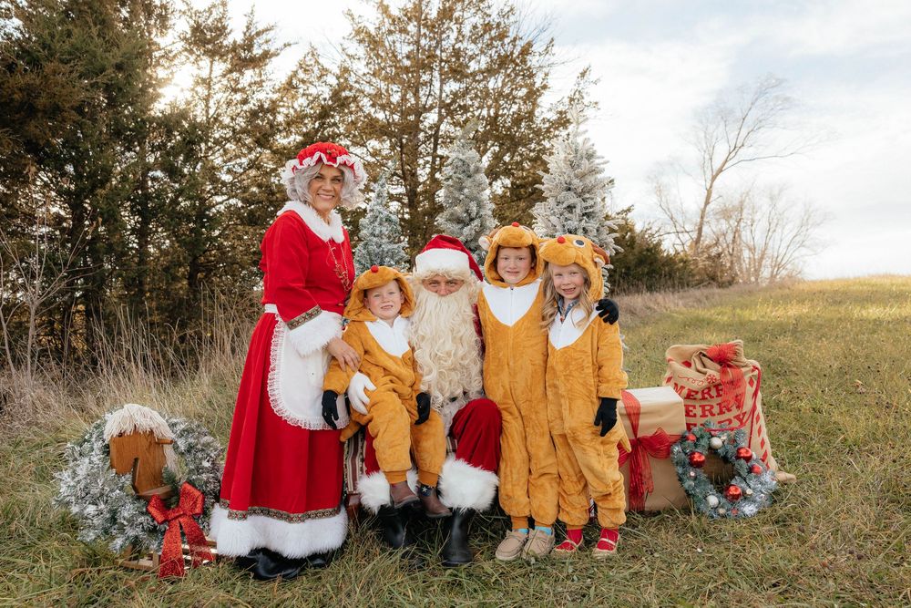Outdoor family photo session in autumn field with warm earth-toned clothing and natural scenery.