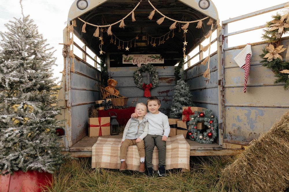 A rustic barn wedding ceremony setup with hay bales for seating and twinkling lights strung overhead.