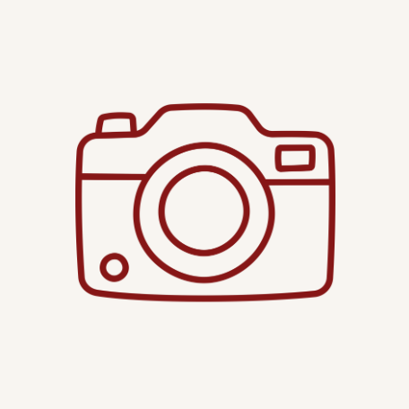 Simple red line drawing of camera icon on white background.