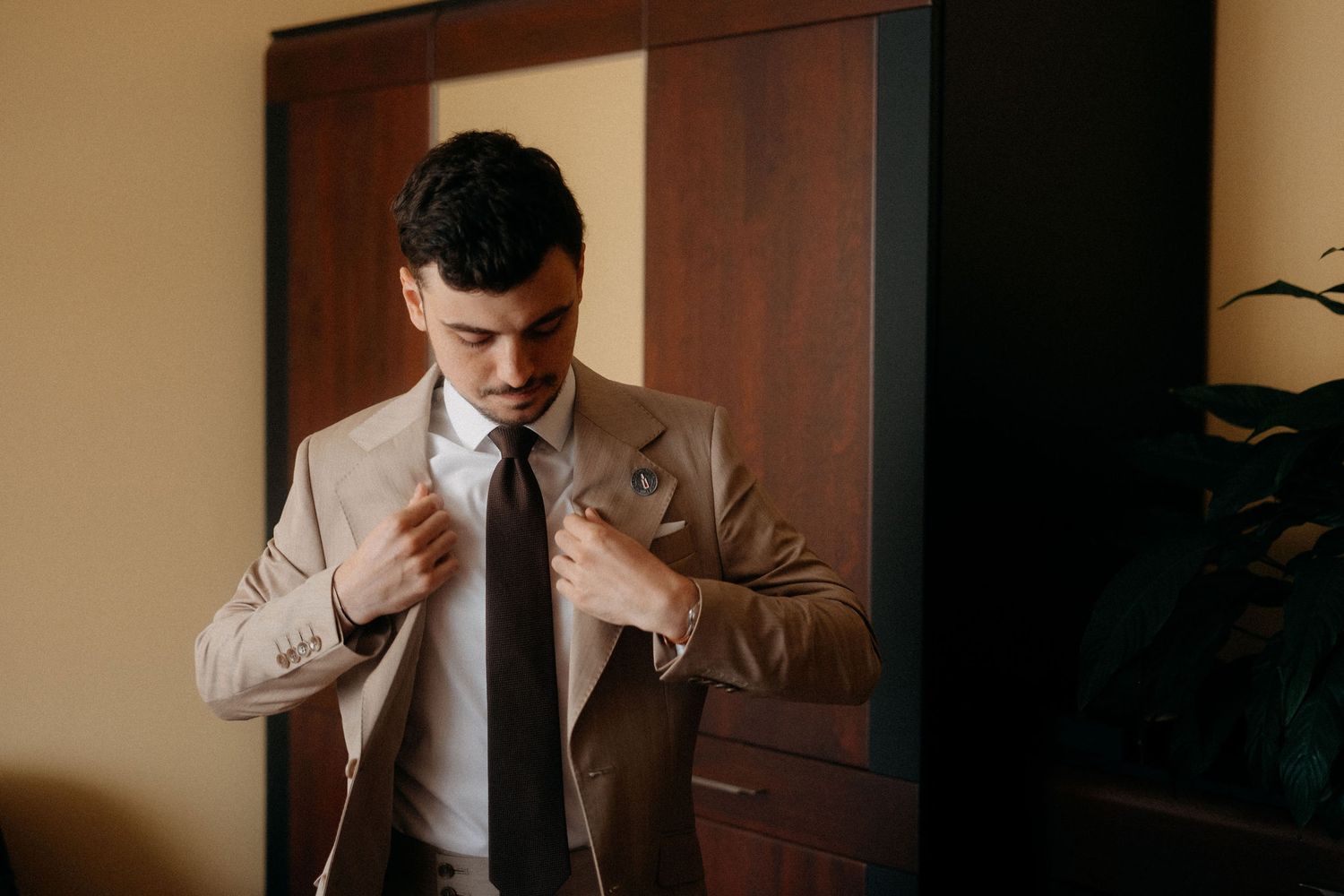 Person adjusting tie while wearing formal business attire.
