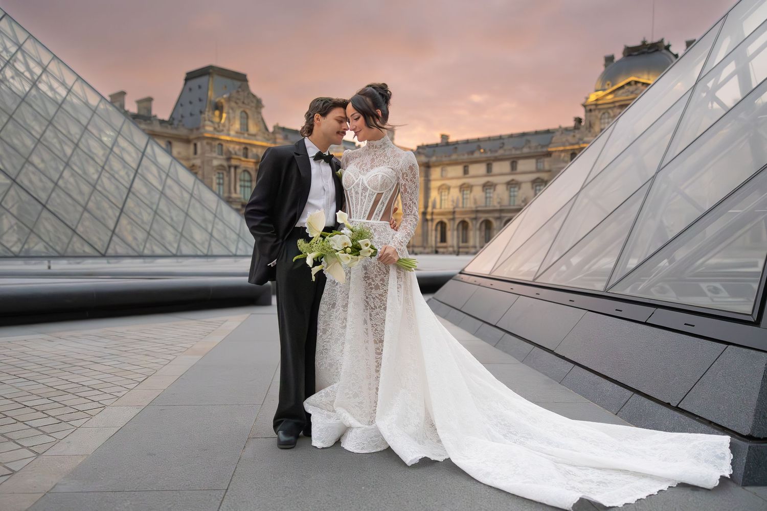 Romantic wedding portraits captured near the glass pyramids of the Louvre at sunset.