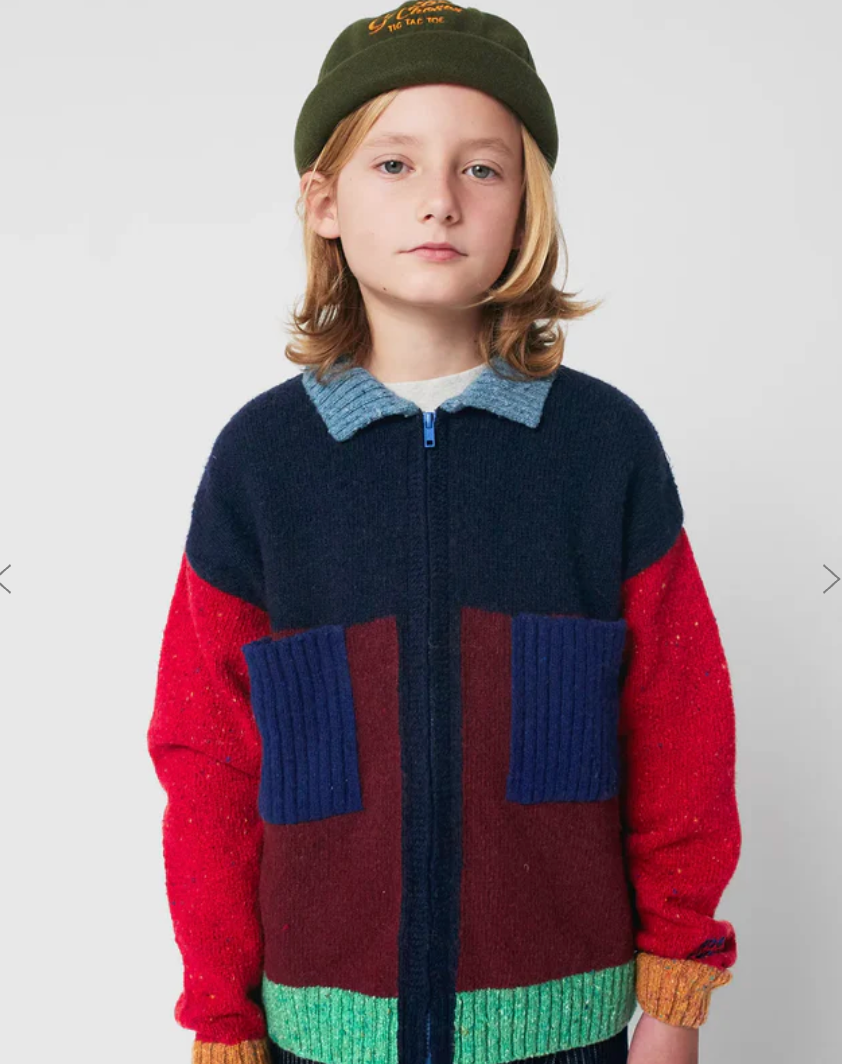 Colorblock knit sweater with navy, red, and green panels featuring a grey collar and front zipper closure.