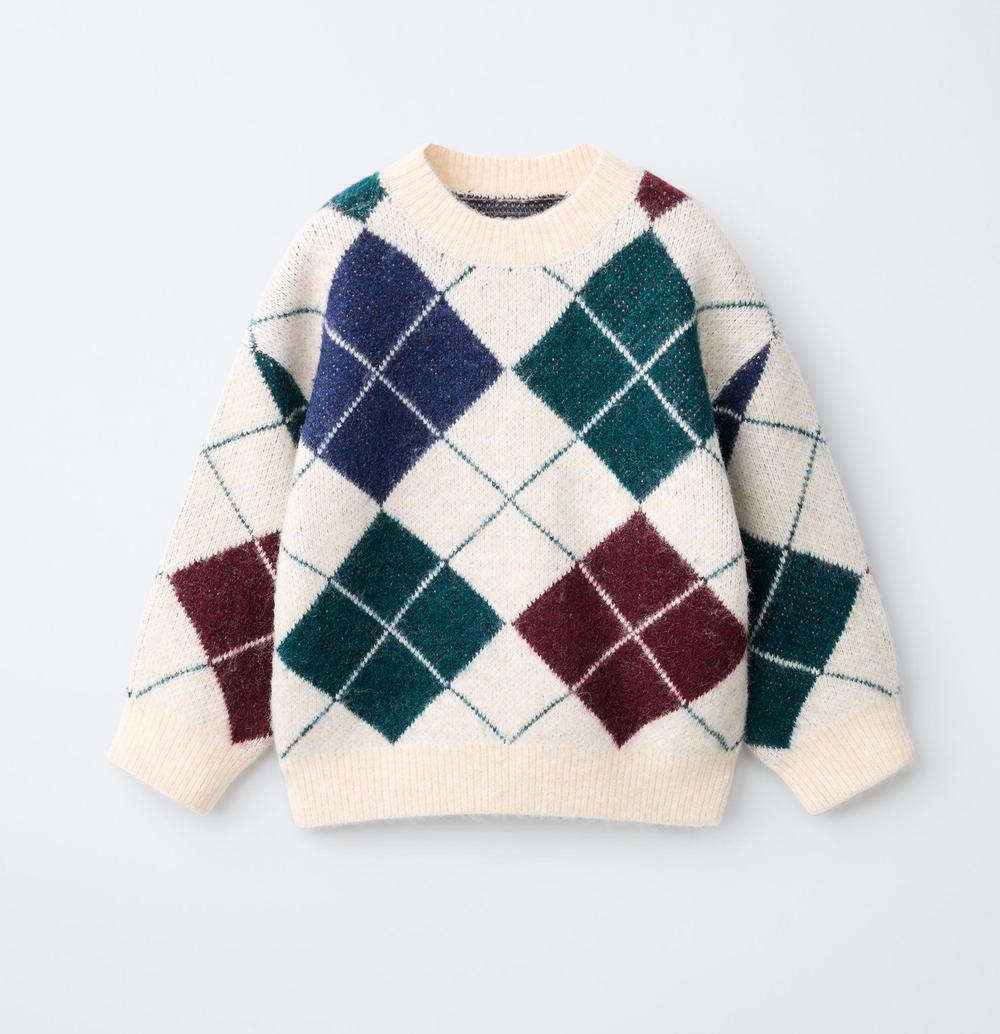 Cream knit kids sweater with an argyle diamond pattern in navy, forest green and burgundy, with a ribbed crew neckline and cuffs.
