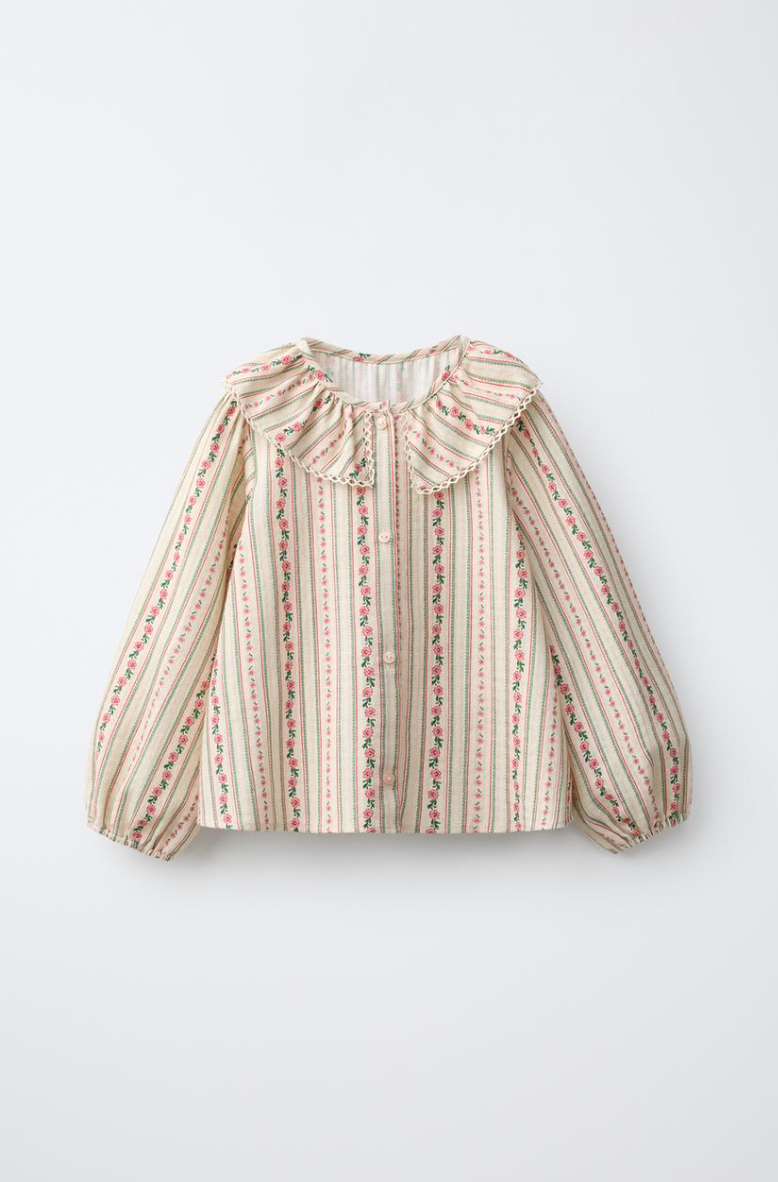Cream floral striped blouse with a ruffled Peter Pan collar, button front and gathered puff sleeves with pink and green vertical rose print.