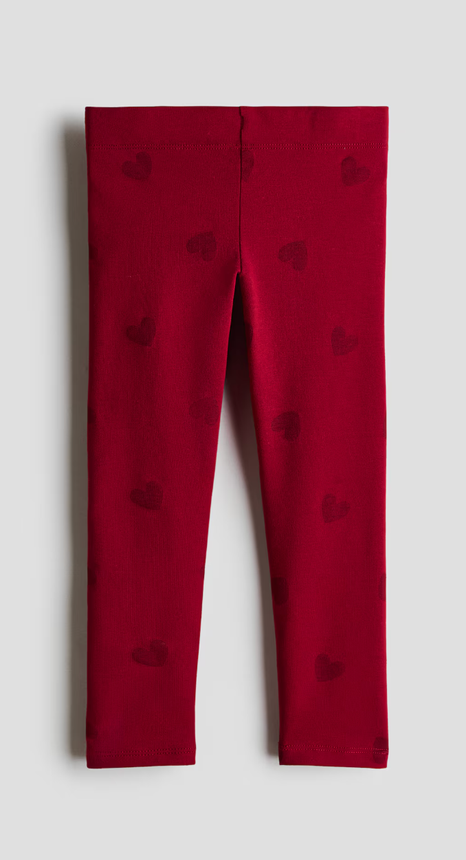 Dark red children's leggings with a subtle tonal heart print, shown flat from the front with a soft stretch waistband.