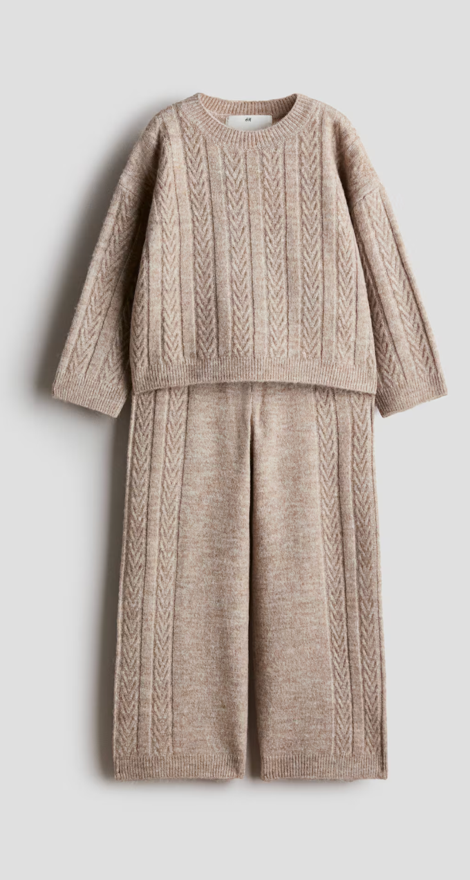Beige cable-knit two-piece set with a long-sleeve crewneck sweater and matching wide-leg knit pants, laid flat.