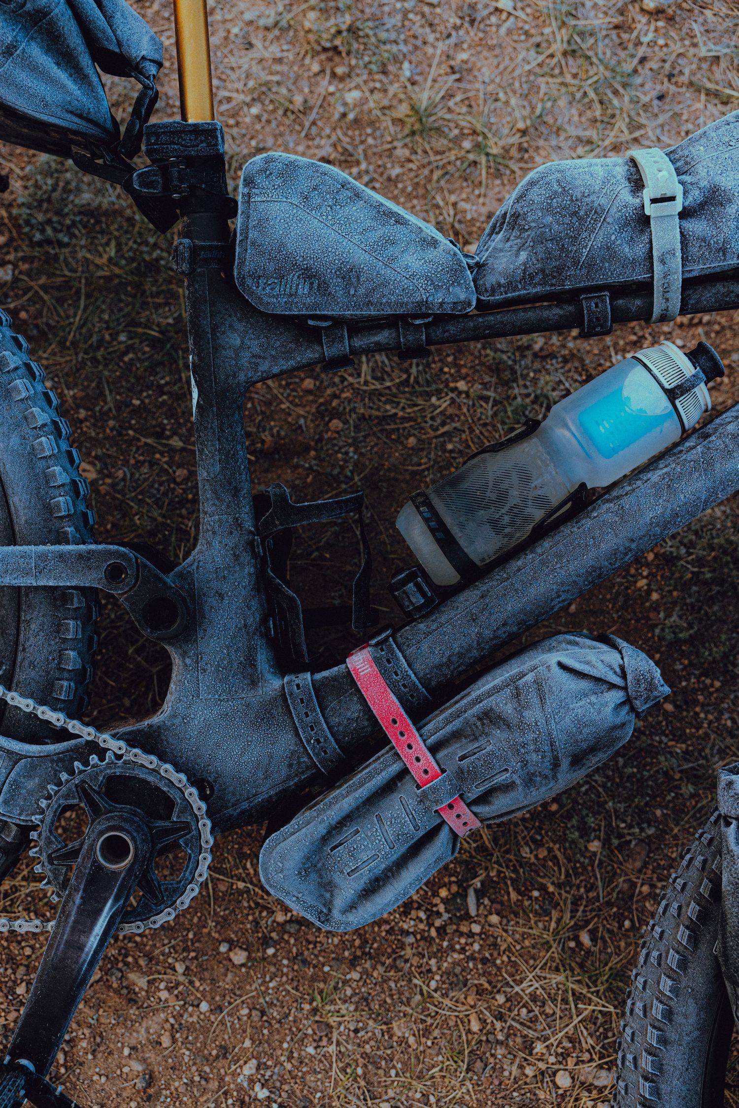 Close-up sequence of a mountain bike's rear suspension and shock absorber mechanism in dusty conditions.