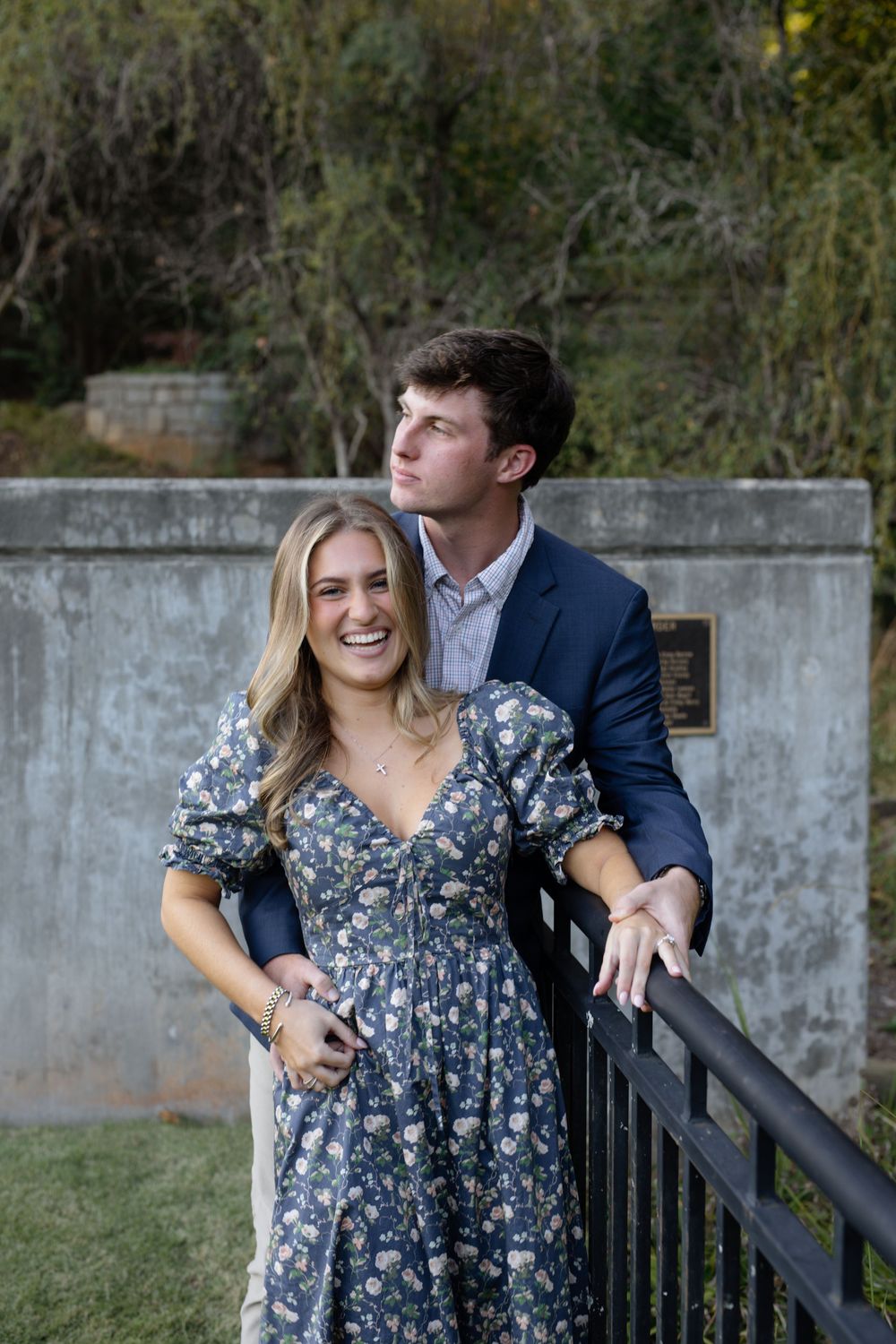 Playful couple sharing candid moments on a garden bench during an engagement session.