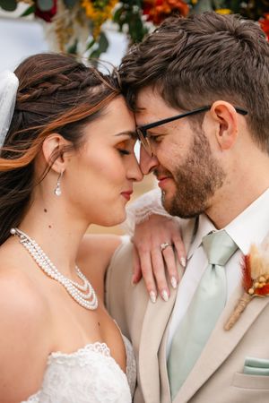 Romantic close-up wedding portraits with pearl necklace and autumn floral details.