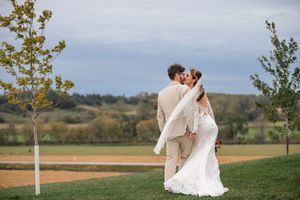 Romantic outdoor wedding portraits in a scenic countryside setting.